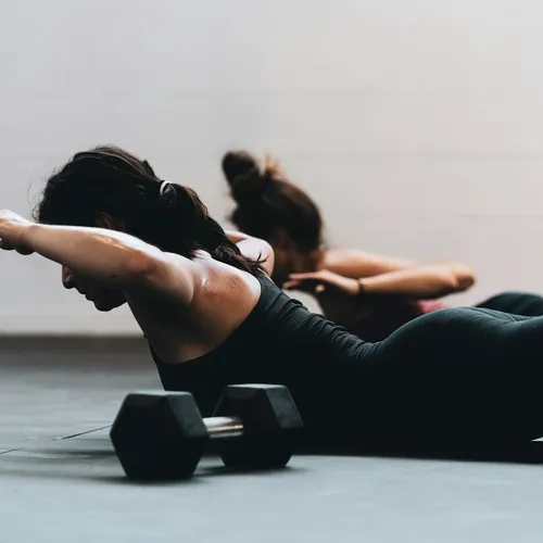 Dos personas practicando pilates en grupo reducido con luz natural